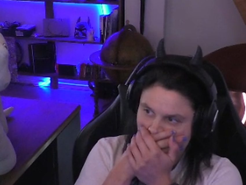 Audebasix, la main devant la bouche, rit pendant un live
